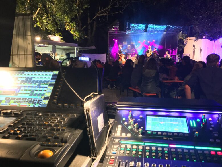 Audiomischpult mit Blick auf die Bühne und das Publikum beim KIK Openair