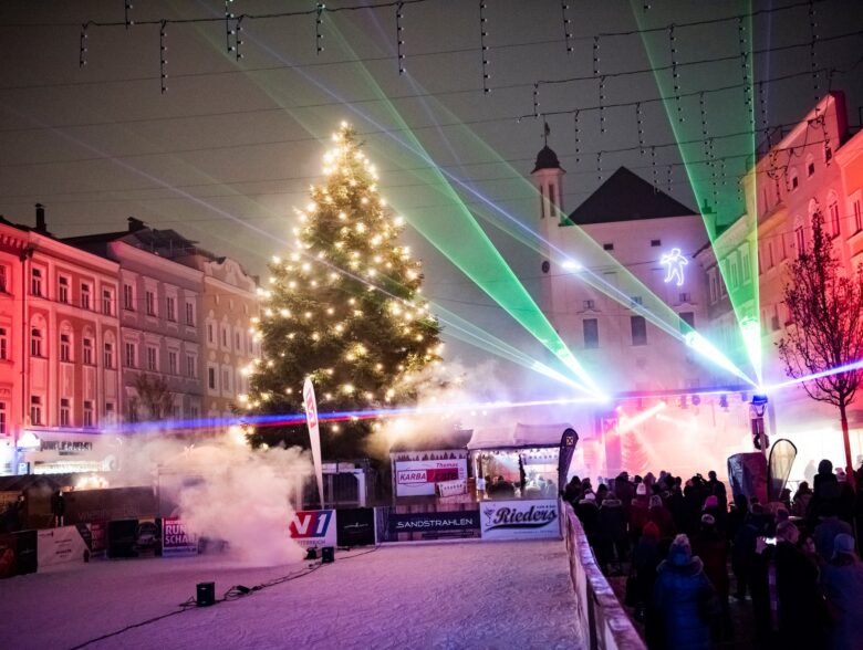 Lasershow mit Lichtstrahlen und Weihnachtsbaum auf dem Rieder Hauptplatz