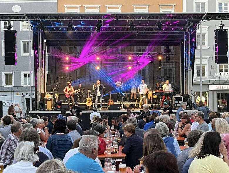 Band auf einer farbig beleuchteten Bühne beim Rieder Kultursommer 2022