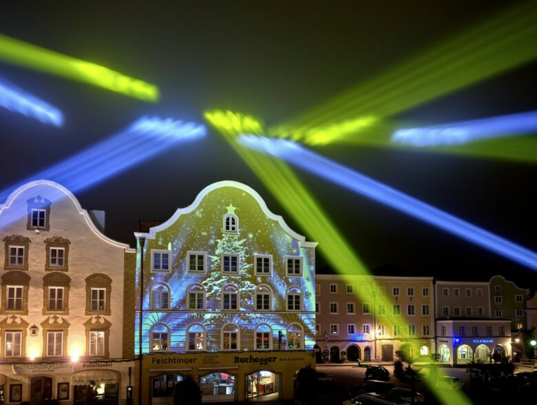 Gelbe und blaue Lichtstrahlen über den Fassaden bei den Schärdinger Lichtspielen