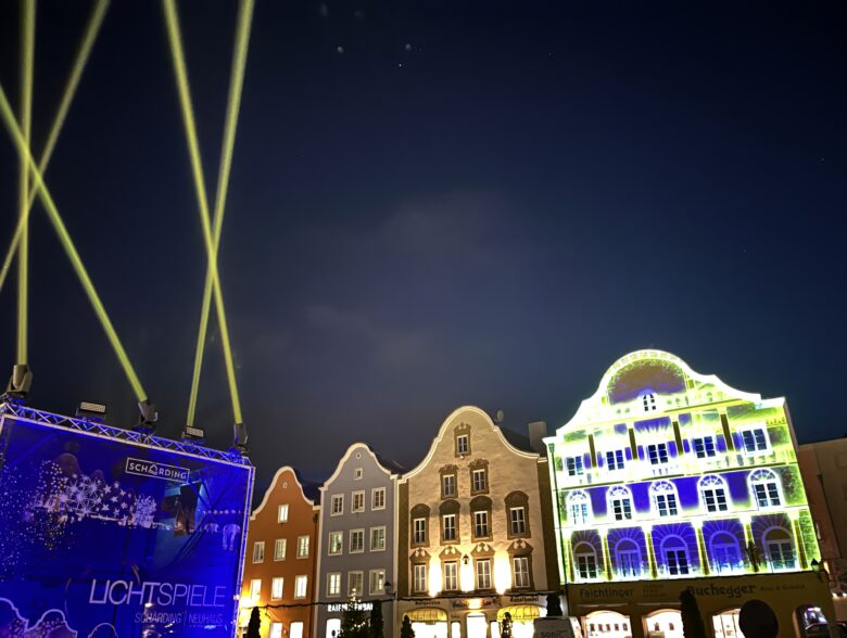Lichtstrahlen über farbig beleuchteten historischen Fassaden