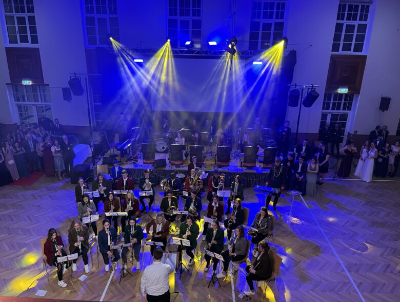 Orchester auf einer blau beleuchteten Bühne mit gelben Lichtstrahlen