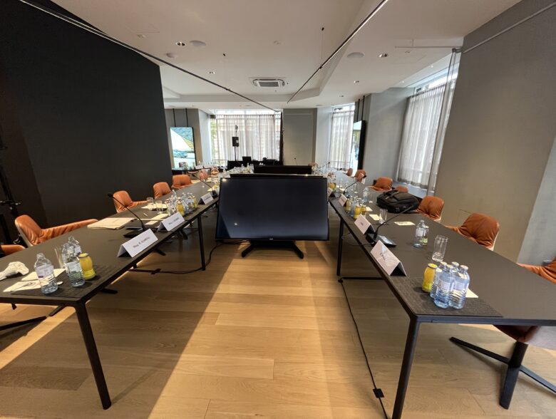Vorbereiteter Besprechungsraum mit Konferenztisch und Bildschirmen