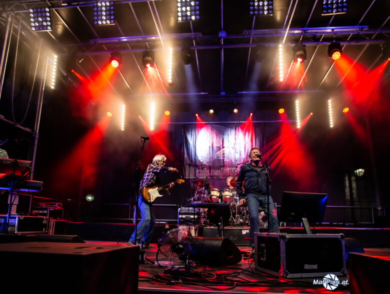 Band unter roten und weißen Scheinwerfern beim Konzert von Wir 4 in Schärding