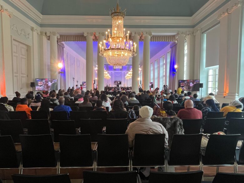Bestuhlter Festsaal mit Kronleuchtern und beleuchteter Bühne in Ansbach