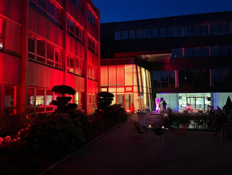 Rot beleuchtete Gebäudefassade bei einer Veranstaltung von Högl