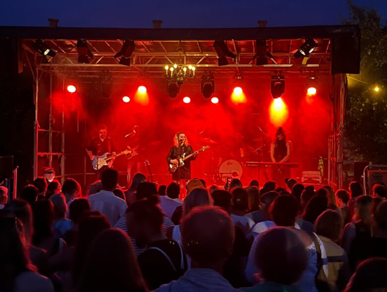 Rot beleuchtete Konzertbühne mit Publikum beim AVEC-Konzert im OKH
