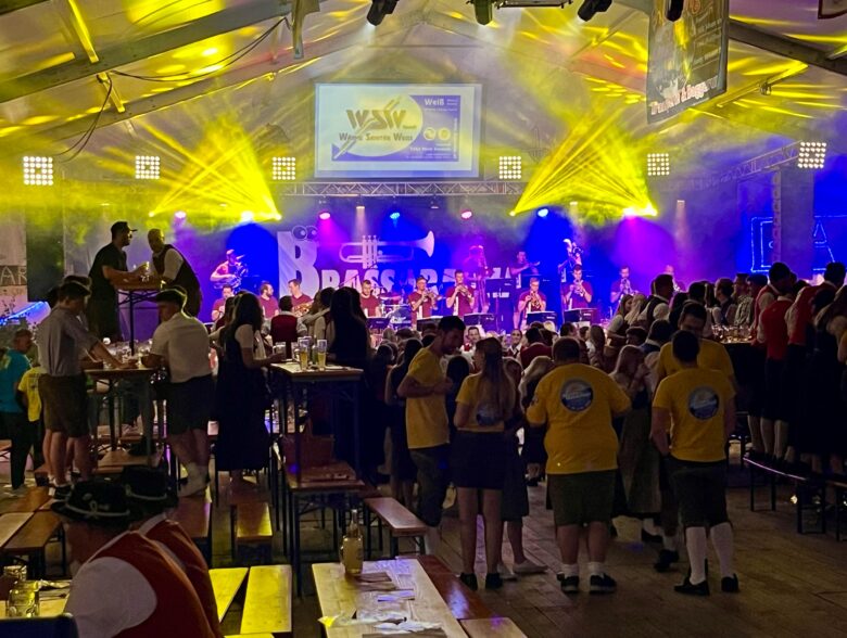 Publikum vor der gelb und blau beleuchteten Bühne beim Musikfest in Maria Schmolln