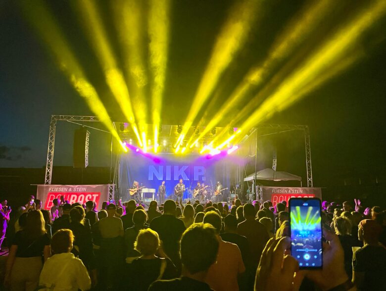 Gelbe Scheinwerferstrahlen über dem Publikum beim Konzert von Nik P. in Ried