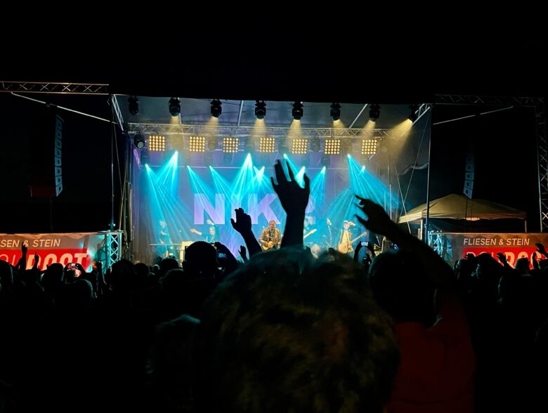 Publikum vor einer blau beleuchteten Bühne beim Konzert von Nik P. in Ried