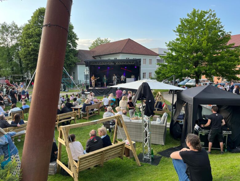 Mobile Bühne mit Zuschauern auf einer Wiese bei einer Veranstaltung in Peuerbach